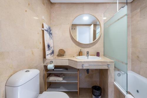 a bathroom with a toilet and a sink and a mirror at Coto Real 2412 KHIOS in San Luis de Sabinillas