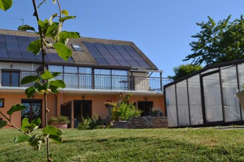 a house with solar panels on the roof at Maison 3 chambres, 3 SdB, terrasse, piscine, spa in Meyrié