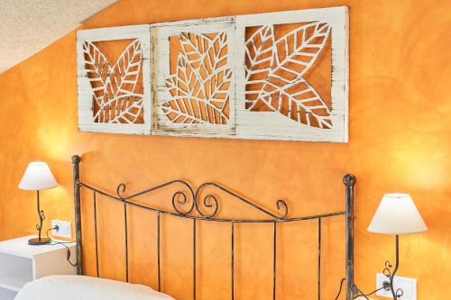 a bedroom with an orange wall with a bed and two lamps at Casa Dakar in Valdemaluque