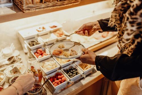 a person is getting food from a buffet at Dorfcafe Unken Hotelpension sWirtshaus im Dorf in Unken