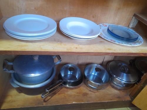a shelf with plates and pots and pans on it at AparWil in Encarnación