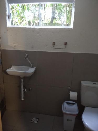 a bathroom with a sink and a toilet and a window at Pousada Casa das Flores in Sao Jorge