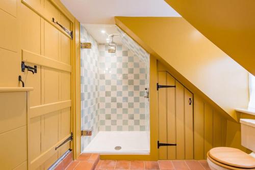 een badkamer met een douche en een toilet bij Rogue's Cottage - Secluded gem by the sea in Deal