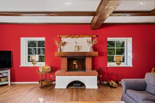 a living room with red walls and a fireplace at Ferienhaus "Altes Backhaus" - Gut Kletkamp in Kletkamp