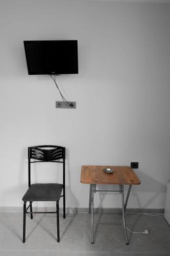 een stoel, een tafel en een televisie aan de muur bij Hotel Resat in Izmir
