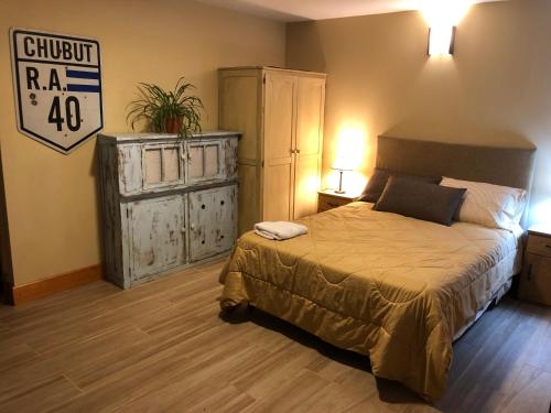 a bedroom with a bed and a dresser with a sign at Santa Clara in San Carlos de Bariloche