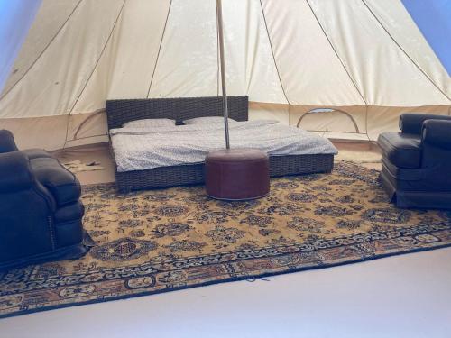 a room with a tent with a bed and two chairs at Go Wild Glamping in Sibiu