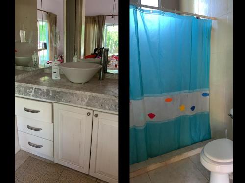 a bathroom with a toilet and a shower curtain at Villa Camilla in Puerto Aventuras