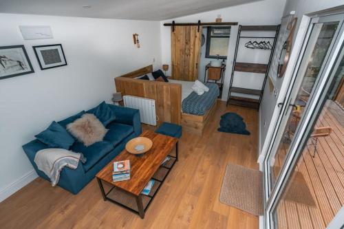 ein Wohnzimmer mit einem blauen Sofa und einem Tisch in der Unterkunft Lakeside Lodge- 'Swallow' in Bishampton