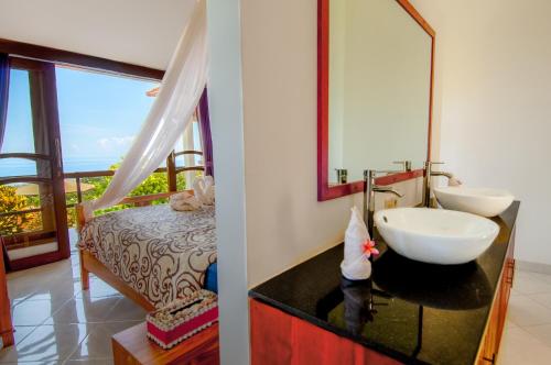 ein Bad mit einem Waschbecken und einem Spiegel in der Unterkunft Villa Tanjung Lovina in Lovina