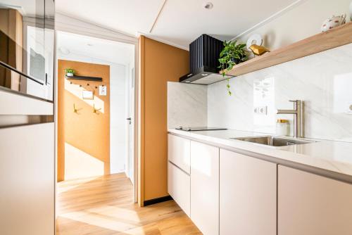 a kitchen with white cabinets and a sink at Charley's Wellness Suite in Westkapelle