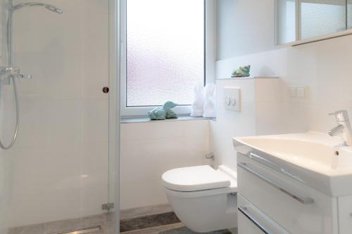 uma casa de banho branca com um WC e um lavatório em Boy5 12 Boysens5 em Westerland