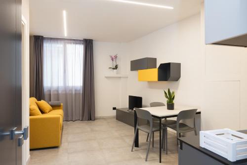 a living room with a yellow couch and a table at Amiata Suite in Abbadia San Salvatore