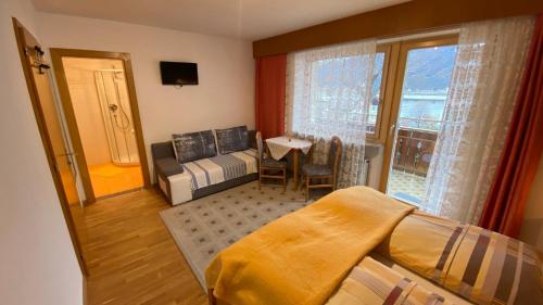 sala de estar con cama y ventana en Haus Mairösl, en Silandro
