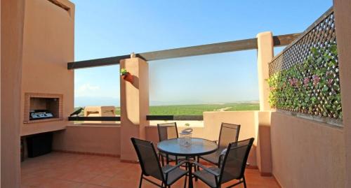 patio ze stołem i krzesłami na balkonie w obiekcie Casa Leona: Fully furnished, secure golf resort penthouse apartment with gorgeous views in Murcia w Murcji