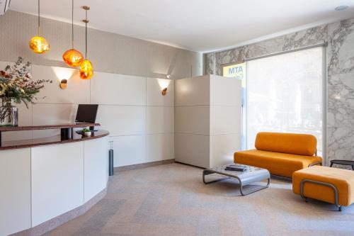 a living room with an orange chair and a table at Hotel Macià Plaza in Granada