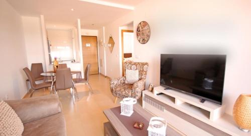ein Wohnzimmer mit einem großen Flachbild-TV in der Unterkunft Casa Leona: Fully furnished, secure golf resort penthouse apartment with gorgeous views in Murcia in Murcia