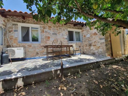 a picnic table in front of a stone house at Confortable house in nature in Fofóla