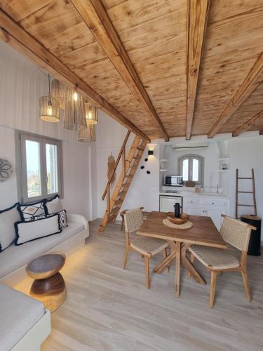 un soggiorno con soffitto in legno, tavolo e sedie. di Lovely House at Oia Village Center a Oia