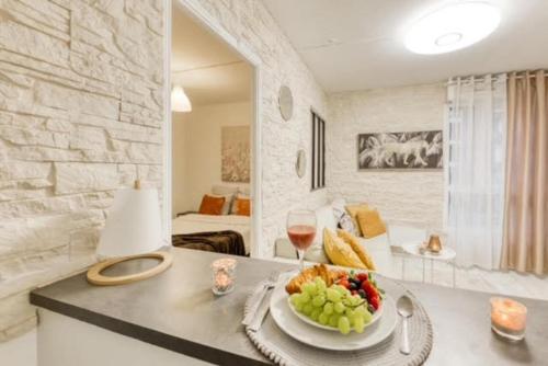 - une table avec un bol de fruits et un verre de vin dans l'établissement Le cosy DisneyLand Paris, à Montévrain