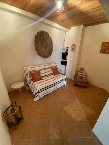 ein Wohnzimmer mit einem Bett und einer Holzdecke in der Unterkunft Coquette maison de village pour 4 pers in Quinson