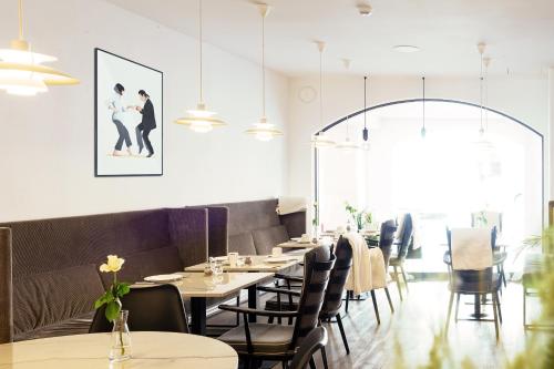 a restaurant with tables and chairs and a picture on the wall at Altstadthotel Wetzel in Mühldorf