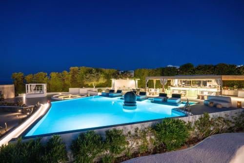 a large swimming pool in a backyard at night at Lovely House at Oia Village Center in Oia
