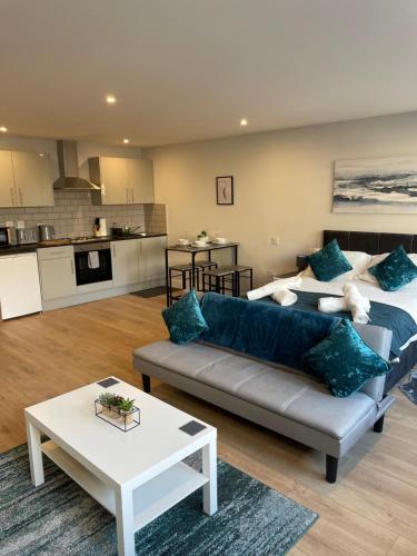 a living room with a couch and a kitchen at Modern, Stylish Studio Apartment in Central Northampton in Northampton