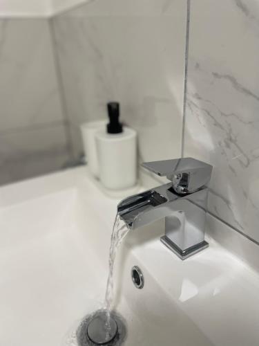 a sink with a faucet in a bathroom at Super-King Bed Studio Apartment in Central Northampton in Northampton