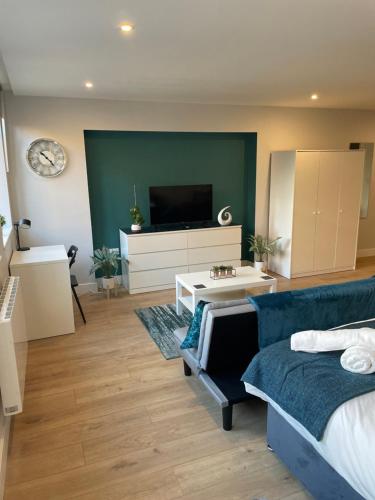 sala de estar con cama y TV en Modern, Stylish Studio Apartment in Central Northampton en Northampton