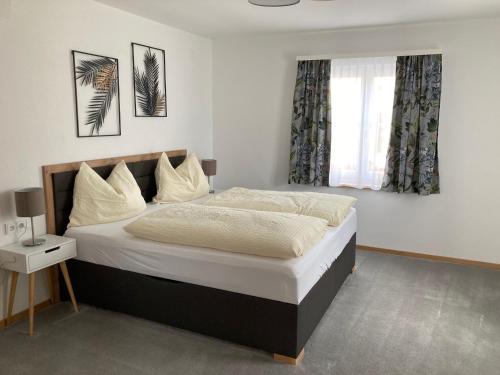 - une chambre avec un grand lit et une fenêtre dans l'établissement Apartment Brigitte Schöndorfer, à Strobl
