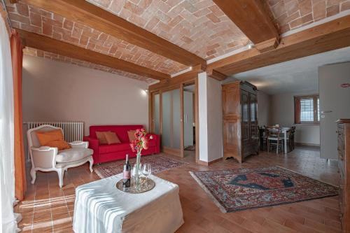 a living room with a red couch and a table at Villa La Martina in Canelli