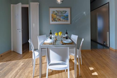 a dining room with a table and white chairs at Villa La Martina in Canelli