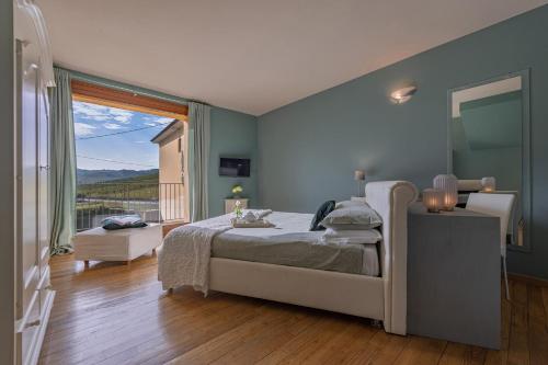 sypialnia z łóżkiem i dużym oknem w obiekcie Villa La Martina w mieście Canelli