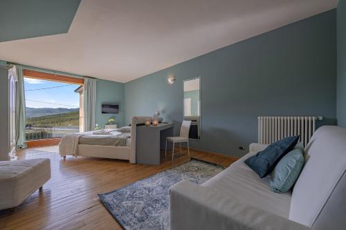 a bedroom with a couch and a bed and a window at Villa La Martina in Canelli