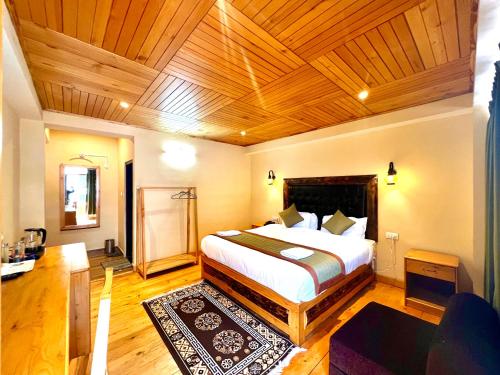 a bedroom with a large bed with a wooden ceiling at The Country House in Lachung