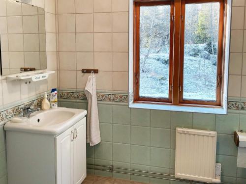 Holiday home ESKILSTUNA V في Malmköping: حمام مع حوض ونافذة