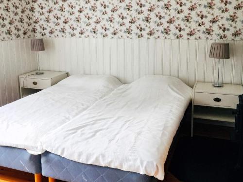 um quarto com uma cama branca e duas mesas de cabeceira em Holiday home ESKILSTUNA V em Malmköping