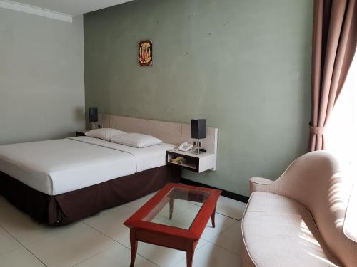 a bedroom with two beds and a couch and a table at N3 Zainul Arifin Hotel in Jakarta