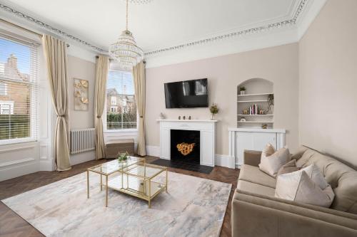 a living room with a couch and a fireplace at Casa Fresa - Taymouth House in Broughty Ferry