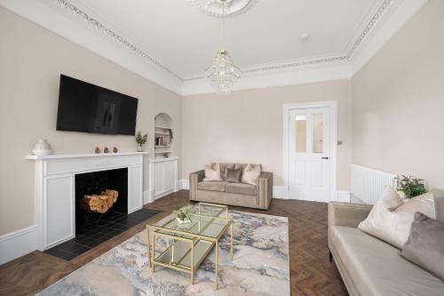 a living room with a couch and a fireplace at Casa Fresa - Taymouth House in Broughty Ferry