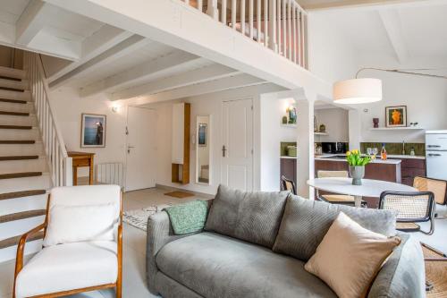 un salon avec un canapé et un escalier dans l'établissement Appartement Cezanne - Welkeys, à Aix-en-Provence