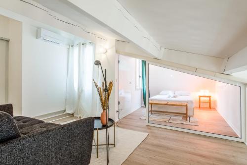 un salon avec un canapé et un lit dans l'établissement Appartement Cezanne - Welkeys, à Aix-en-Provence