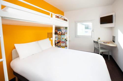 a bedroom with a white bed and a desk in it at hotelF1 Fréjus Roquebrune sur Argens in Roquebrune-sur-Argens