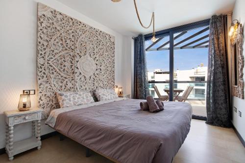a bedroom with a large bed and a large window at Casamar2197 in Cotillo