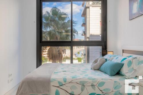 een slaapkamer met een bed en een groot raam bij Apartamento Calpe Beach II 2E - Grupo Turis in Calpe