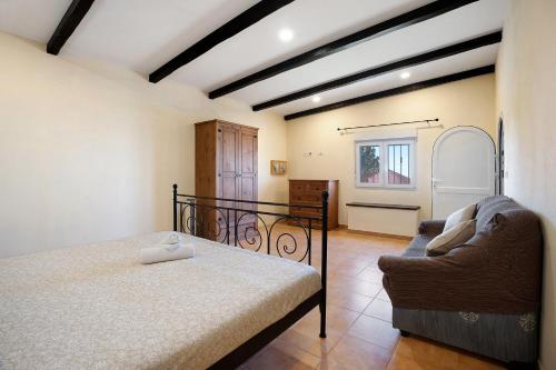 a bedroom with a bed and a couch at Casa Andrea in Tacoronte