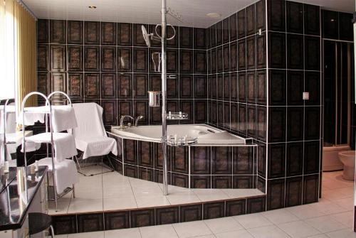 ein Bad mit einer Badewanne, einem Tisch und Stühlen in der Unterkunft Apartament Senator 115m2 in Kattowitz