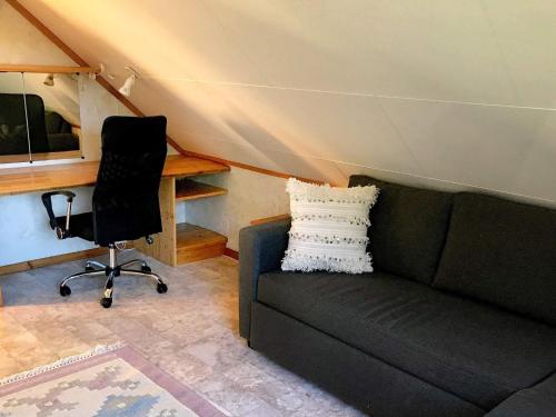 a living room with a couch and a chair at Holiday home Nuvsvåg 