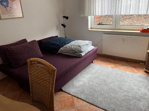 sala de estar con sofá púrpura y ventana en Nette Ferienwohnung nahe Düsseldorf, en Kaarst